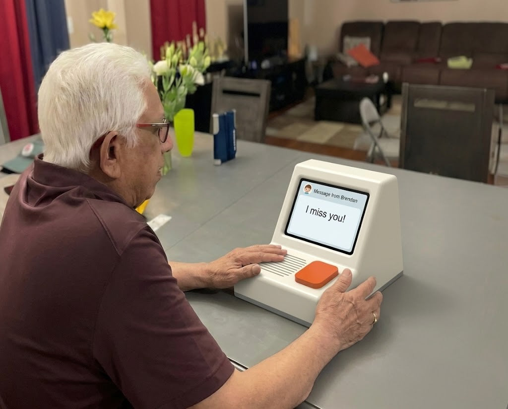 An older man at his dining table with a message on his Memobox